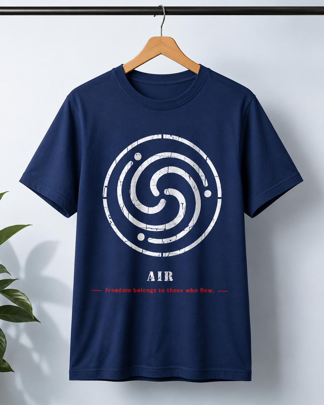 A navy blue short-sleeve t-shirt hanging on a wooden hanger against a light gray wall. The shirt features a large distressed white circular swirl graphic on the chest, with the word 'AIR' printed below in white and a small red line of text underneath reading 'Freedom belongs to those who wear.